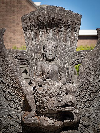 Close-up of Vishnu on Garuda in Indonesian lavastone, frontal view with fanned feathers behind the head