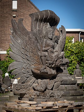 Vishnu statue on Garuda in Indonesian lavastone, three-quarter view with carved feathers and bird profile