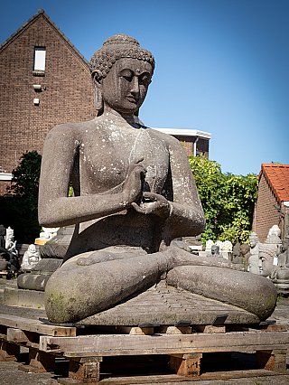 Indonesisch lavastenen Boeddhabeeld zittend met dharmachakra mudra, driekwartaanzicht links