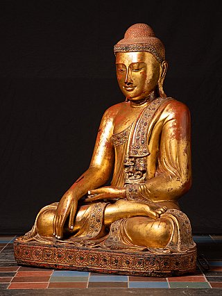 Wooden Buddha statue from Burma (Myanmar), seated, three-quarter view with base visible