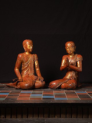 Pair of Burmese wooden monk statues, seated, one with namaskara mudra, angled view