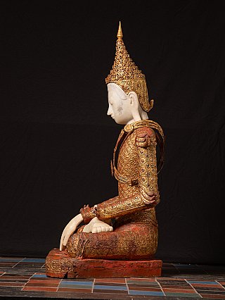 Burmese Buddha statue in wood, seated side profile with tall crown