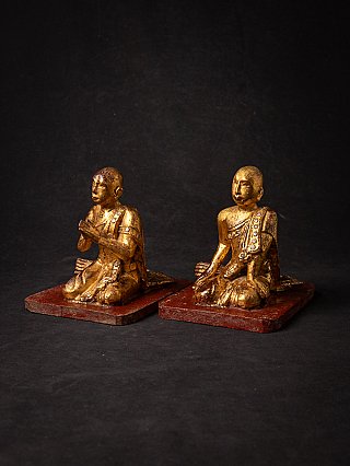 Pair of wooden monk statues from Myanmar, three-quarter view on red bases