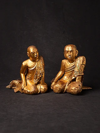 Paar vergoldete Holz-Mönchsfiguren aus Burma, sitzend, schräge Vorderansicht vor dunklem Grund