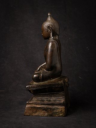 Burmese bronze Buddha statue side profile, showing elongated ear and textured hair