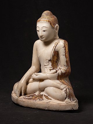Burmese marble Buddha statue with traces of red and gold pigment, three-quarter left view