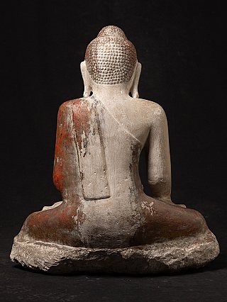 Rear view of the marble Buddha statue showing draped robe and rough base edge
