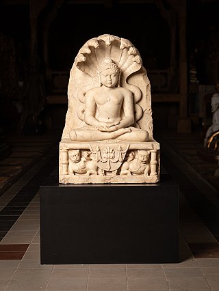 Marble Jain statue from India on black base, full-front view with cobra hood and base relief
