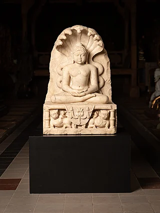 Marble Jain statue from India on black base, full-front view with cobra hood and base relief