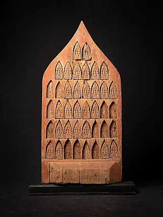 Antique wooden Burmese temple panel with rows of arched niches and small reliefs, front view