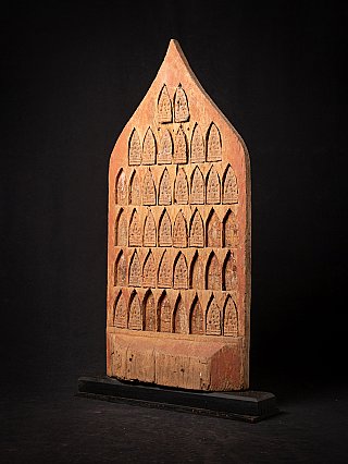 Antique Burmese temple panel shown in three-quarter view with carved niche reliefs