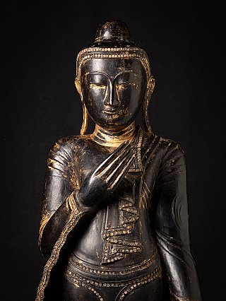 Front face detail of the Burmese wooden Buddha, with hand raised near the chest