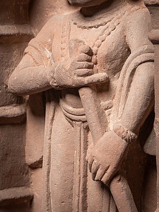 Hands detail of the main figure gripping the staff