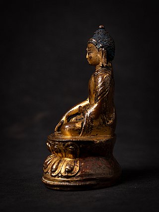 Gilt Tibetan Shakyamuni Buddha statue seated, side profile with lotus base