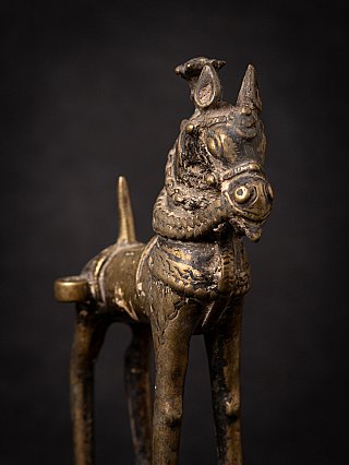 Close-up of the bronze horse head with worn surface and ornament, angled view