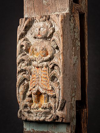Angled detail of the relief figure with worn polychrome paint and panel edge