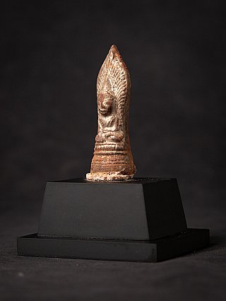 Buddha statue amulet from Burma (Myanmar), three-quarter view showing the side contour and pointed halo