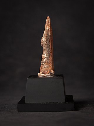 Buddha statue amulet from Myanmar, side profile view showing the relief face and torso