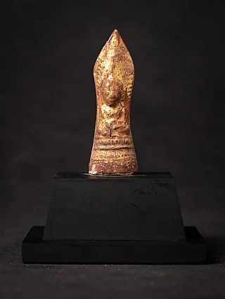 Burmese wooden Buddha amulet, full front view with worn gilded surface on black stand