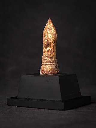 Birmaans houten Boeddha-amulet in driekwartaanzicht, met slijtage in de vergulding