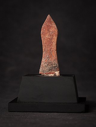 Achterzijde van het Birmaanse houten Boeddha-amulet met verweerde roodbruine ondergrond
