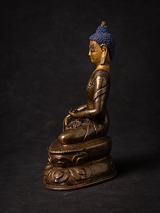 Tibetan bronze Buddha statue seated on lotus base, right side profile