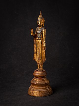 Thai wooden Buddha statue standing in Abhaya mudra, three-quarter view