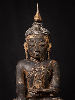 Detail von Gesicht und Brust der burmesischen Buddha-Statue aus Lackarbeit mit langen Ohrläppchen