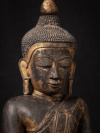 Nahaufnahme des Buddha-Gesichts mit geschlossenen Augen und goldfarbener Abnutzung