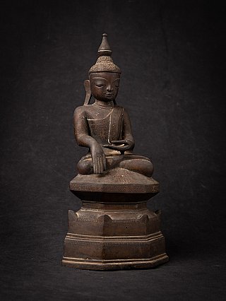 Burmese bronze Buddha statue with bhumisparsha mudra, angled front view on base