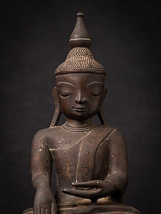 Face and torso detail of the Burmese bronze Buddha, with bhumisparsha gesture visible