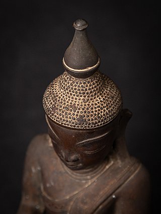 Top view detail of the Burmese bronze Buddha’s textured hair and finial