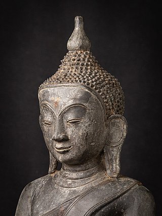 Three-quarter head detail of the Buddha statue, highlighting curled hair and left earlobe
