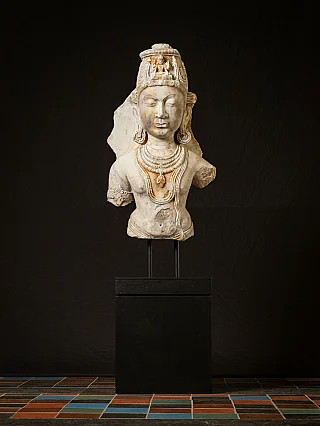Marmeren buste van Avalokiteshvara uit India op sokkel, frontaal overzicht