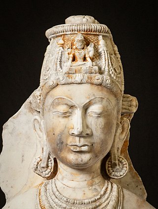 Avalokiteshvara face detail with carved crown and small relief at the front