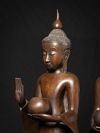 Hands detail of a bronze monk statue from Burma (Myanmar) showing raised hand and alms bowl