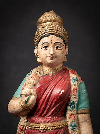 Frontaal detail van Lakshmi met kroon, bindi en opgeheven hand voor de borst