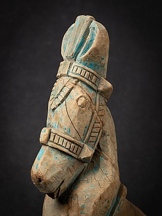 Three-quarter close-up of the horse head showing the eye, muzzle and carved harness