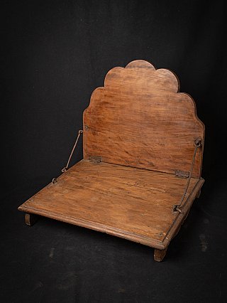 Antique wooden Indian throne, three-quarter view highlighting the scalloped backrest and rods