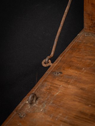 Metal support rod and ring detail with wear marks on the wooden seat