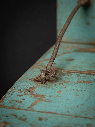 Detail der Metallstrebe auf der Sitzfläche, Rost und abgenutzte türkisfarbene Farbe