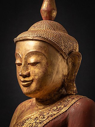 Angled face detail of Burmese wooden Buddha with gilding, ear and robe edge