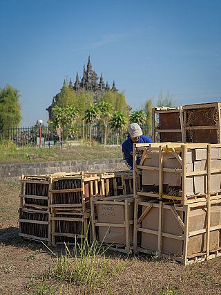 Crates with parts and roof tiles for the teak temple house at the work site