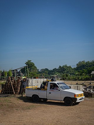 Pickup truck at the build site with stacked materials for the Indonesian temple house