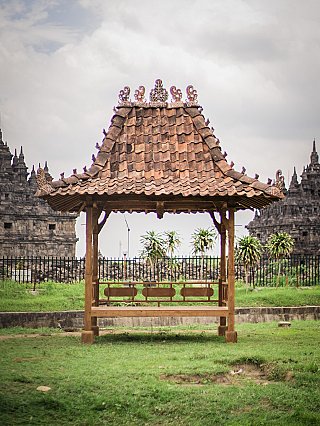 Indonesian teak temple house with tiled roof and open platform, front view outdoors
