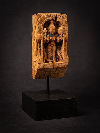 Wooden panel of the standing goddess Parvati from India on display stand, three-quarter left view