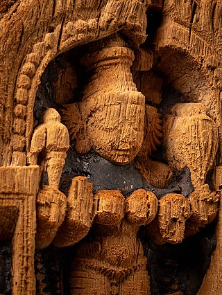 Detail of Parvati’s head and upper torso carved in wood beneath the arch