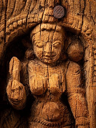 Detail von Gesicht und erhobener Hand Parvatis im Holzrelief