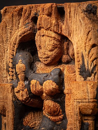 Schuin detail van Parvati’s gezicht en opgeheven hand, met donkere patina rond de arm