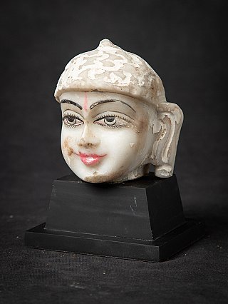 Jain statue head in marble, three-quarter view showing ear and cheek